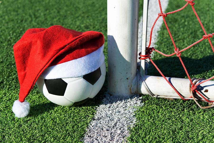 santa claus red hat on soccer ball at green grass